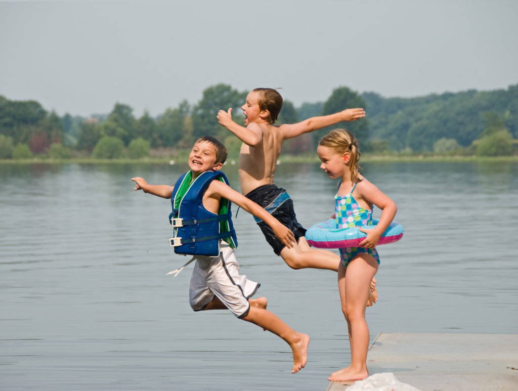 Trois enfants qui sautent dans l'eau