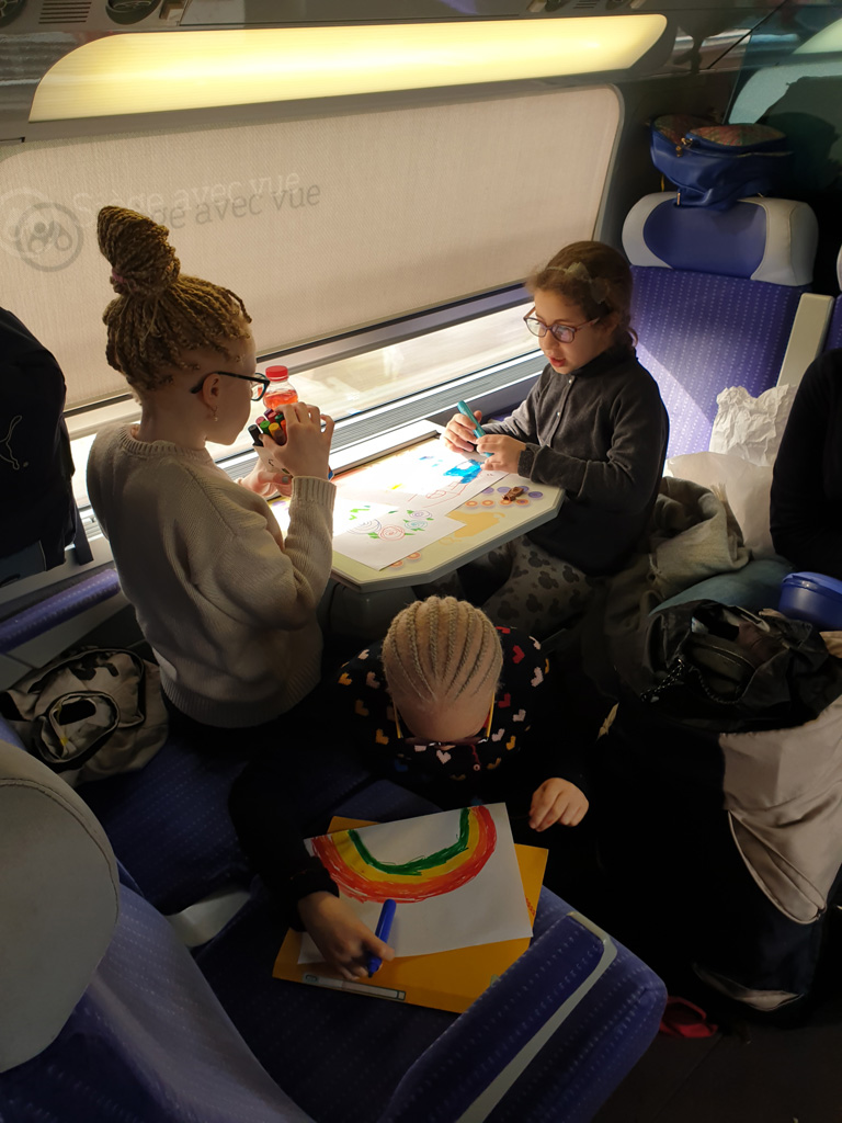 Des enfants font du dessin pendant le voyage en train