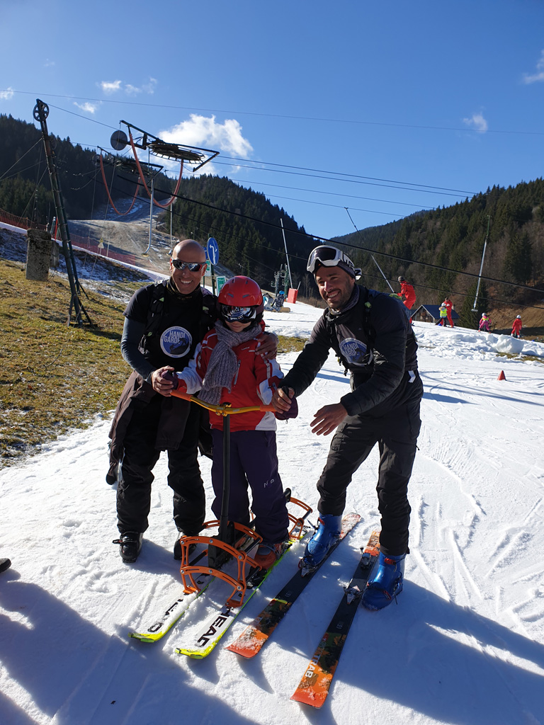 Un enfant et deux encadrants font du ski